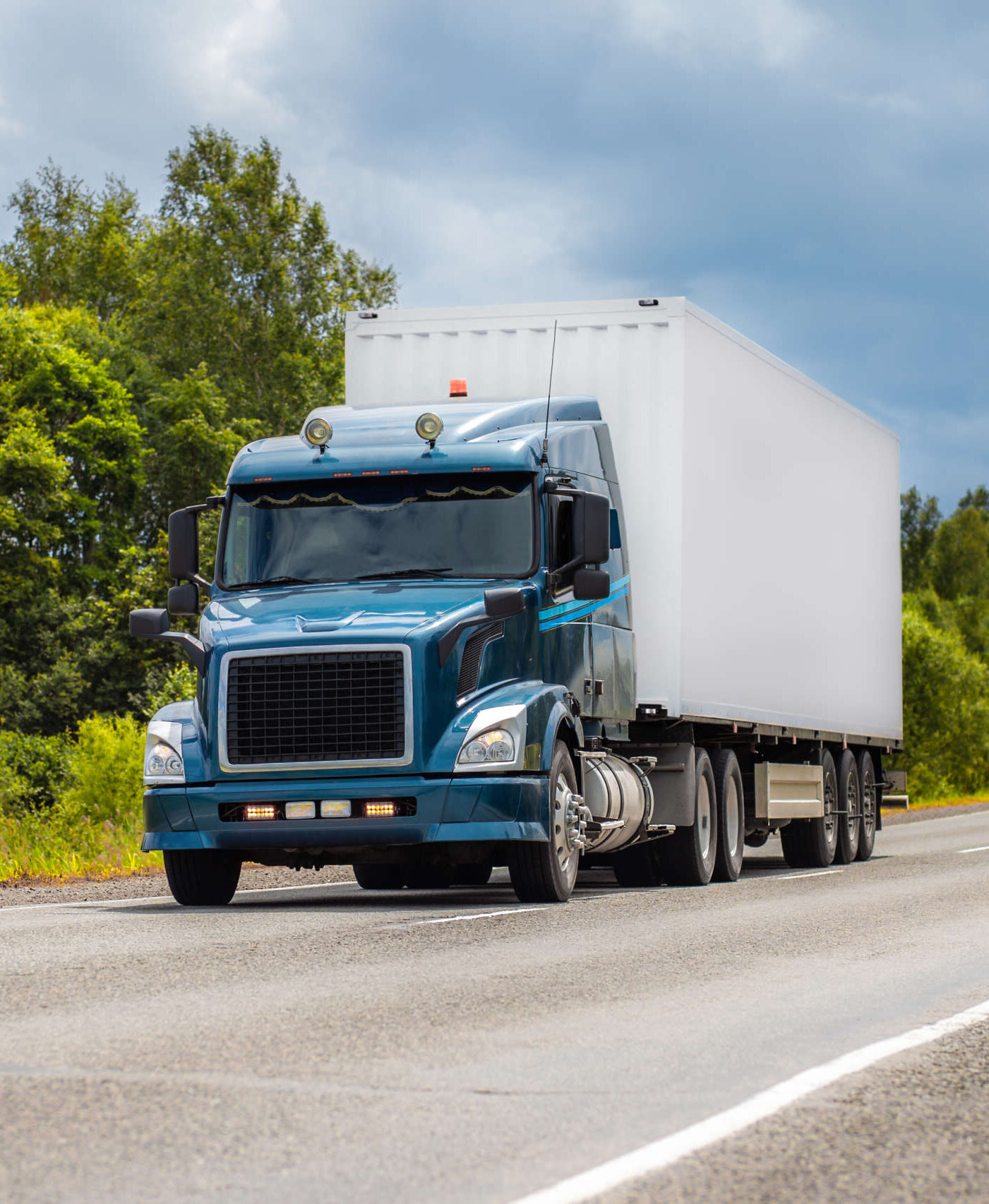 Blue truck on a road in summer