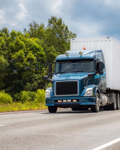 Blue truck on a road in summer